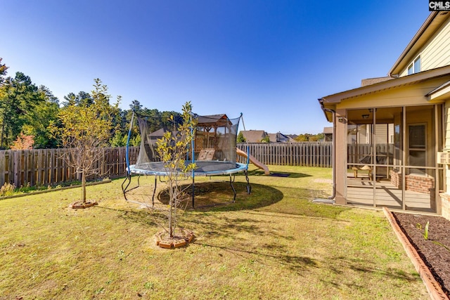 view of yard featuring a trampoline and a sunroom