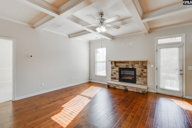 unfurnished living room featuring a stone fireplace, ceiling fan, beamed ceiling, and dark hardwood / wood-style flooring