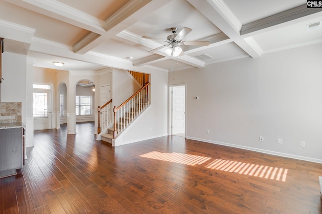 unfurnished living room with coffered ceiling, beamed ceiling, dark wood-type flooring, ornamental molding, and ceiling fan