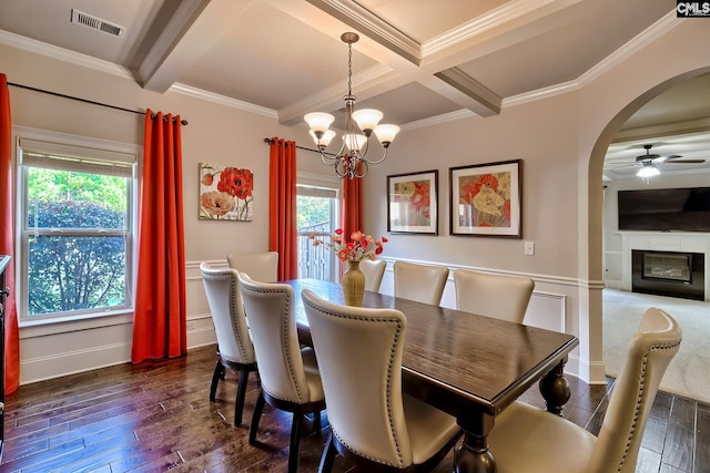 dining area featuring dark wood-type flooring, beamed ceiling, and plenty of natural light