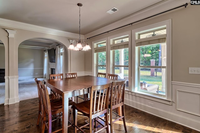 dining area with crown molding, a chandelier, and dark hardwood / wood-style flooring