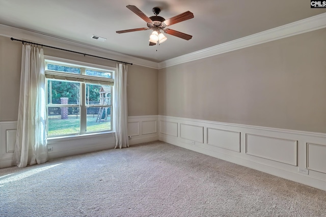 empty room featuring crown molding, carpet flooring, and ceiling fan