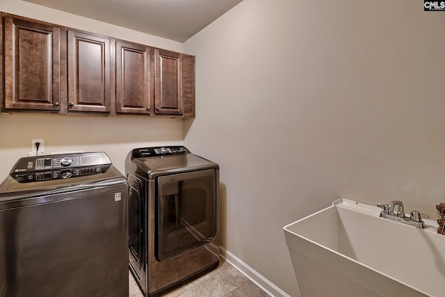 washroom featuring cabinets, sink, and washer and clothes dryer