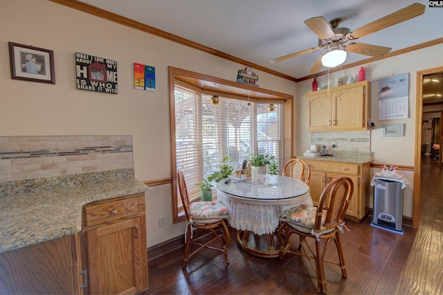 dining room with dark wood-type flooring, crown molding, and ceiling fan