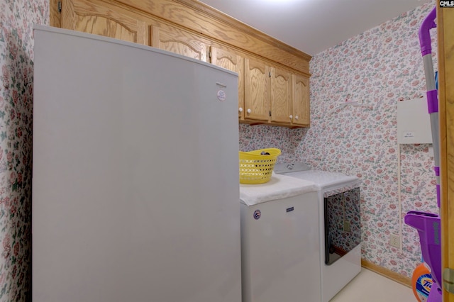 clothes washing area with cabinets and separate washer and dryer