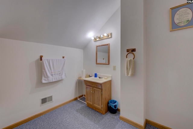 bathroom featuring vanity and lofted ceiling