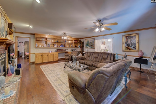 living room featuring built in desk, ornamental molding, dark wood-type flooring, and ceiling fan