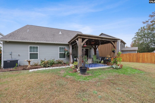 rear view of property featuring ceiling fan, a lawn, a patio area, and central AC unit