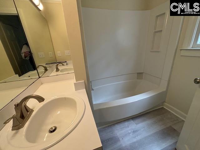 bathroom with vanity, hardwood / wood-style floors, and a bathing tub