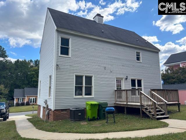 rear view of property featuring a wooden deck, central AC, and a yard