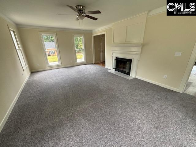 unfurnished living room featuring ornamental molding, carpet flooring, and ceiling fan