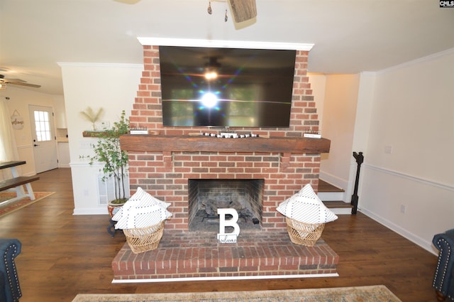 living room with dark wood-type flooring, a fireplace, crown molding, and ceiling fan