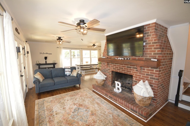 living room with ornamental molding, ceiling fan, dark wood-type flooring, and a brick fireplace