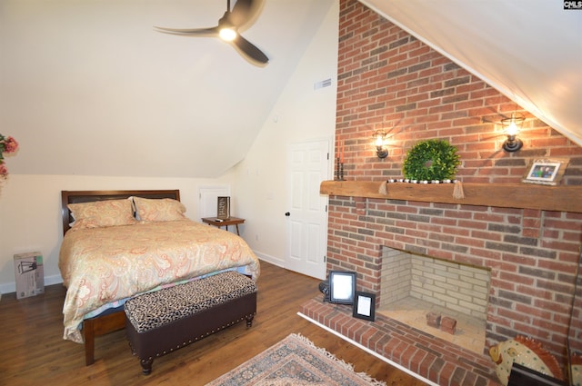 bedroom with ceiling fan, lofted ceiling, a brick fireplace, and hardwood / wood-style floors