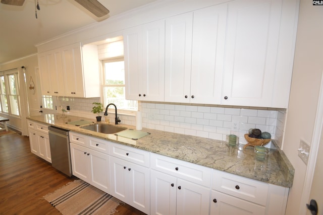 kitchen with dark wood-type flooring, sink, stainless steel dishwasher, white cabinets, and tasteful backsplash