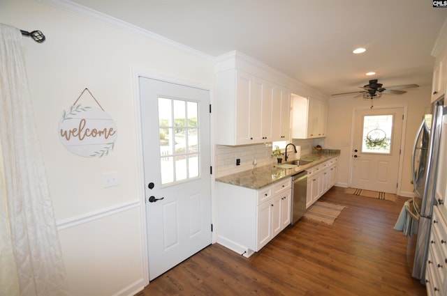 kitchen featuring dark wood-type flooring, sink, white cabinets, appliances with stainless steel finishes, and light stone counters