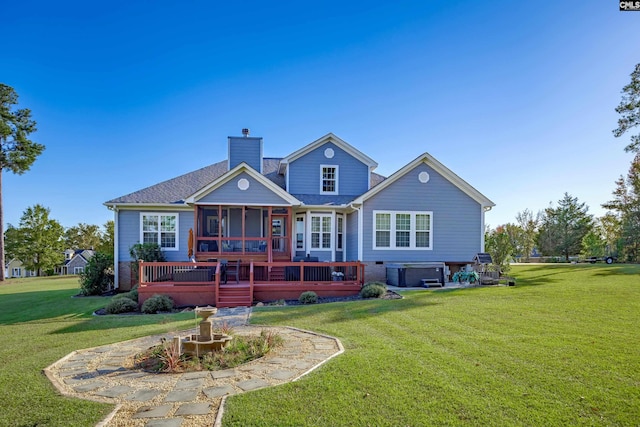 back of house with a sunroom, a yard, a wooden deck, and a hot tub