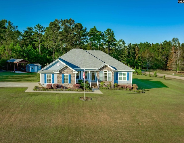 ranch-style home featuring a carport, a front yard, and a storage unit