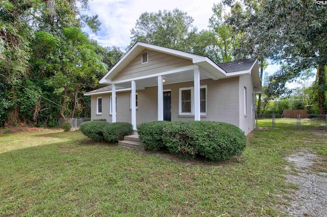 view of front of house featuring covered porch and a front lawn