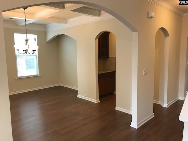 spare room with beam ceiling, coffered ceiling, ornamental molding, and dark hardwood / wood-style floors