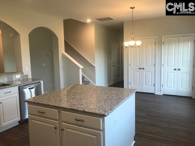 kitchen featuring dark hardwood / wood-style flooring, white cabinetry, light stone countertops, dishwasher, and pendant lighting