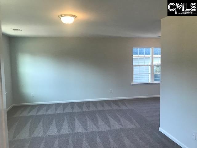 unfurnished room with dark carpet