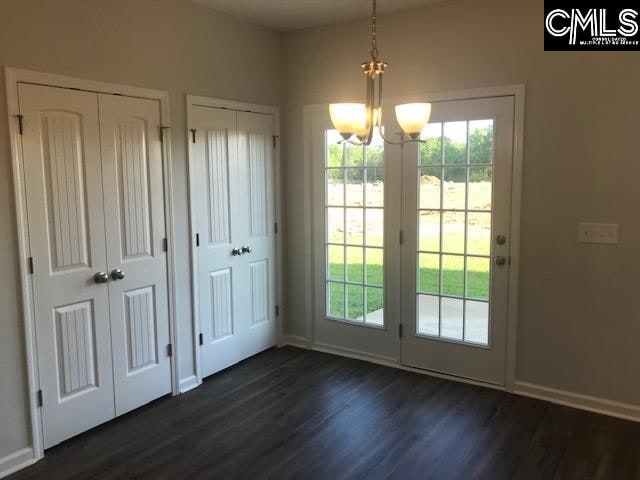 doorway with an inviting chandelier and dark hardwood / wood-style floors