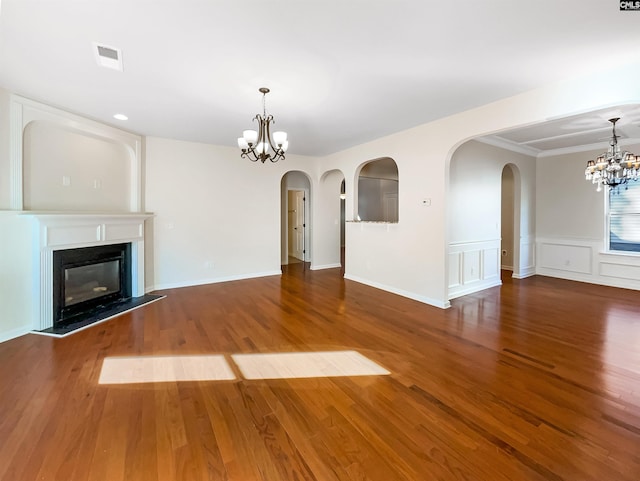 unfurnished living room with a notable chandelier and dark hardwood / wood-style floors