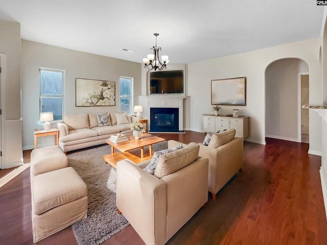 living room featuring dark wood-type flooring and an inviting chandelier