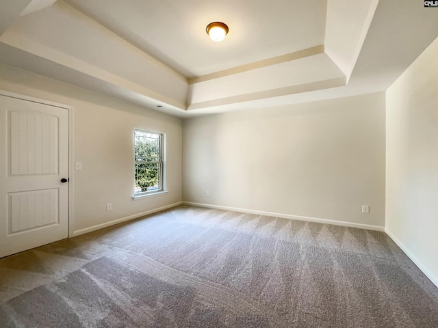 carpeted empty room with a tray ceiling