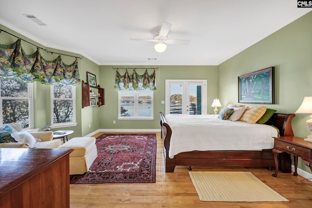 bedroom with french doors, ornamental molding, light wood-type flooring, and ceiling fan