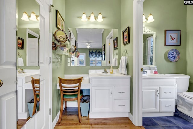 bathroom with vanity, a healthy amount of sunlight, hardwood / wood-style flooring, and toilet