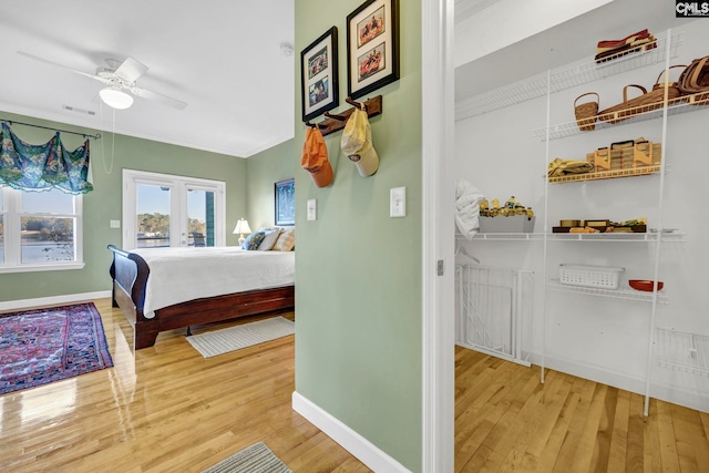 bedroom featuring french doors, ceiling fan, crown molding, and hardwood / wood-style floors