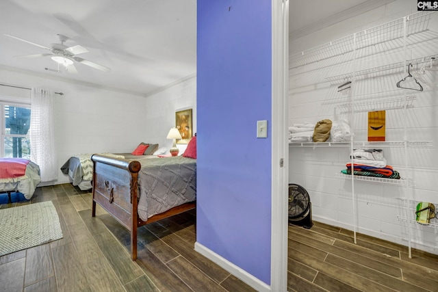 bedroom featuring dark wood-type flooring, ceiling fan, and ornamental molding