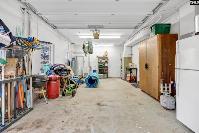 garage featuring white fridge, a garage door opener, and water heater