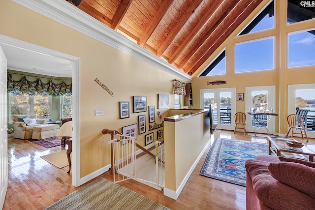 hall with high vaulted ceiling, wooden ceiling, beamed ceiling, and hardwood / wood-style floors