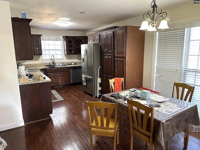 kitchen with sink, dark hardwood / wood-style flooring, hanging light fixtures, stainless steel appliances, and a chandelier