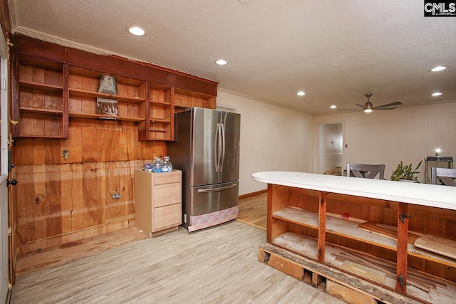 kitchen with a textured ceiling, light hardwood / wood-style floors, stainless steel refrigerator, and ceiling fan