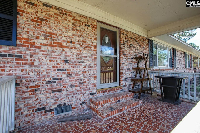 view of exterior entry featuring covered porch