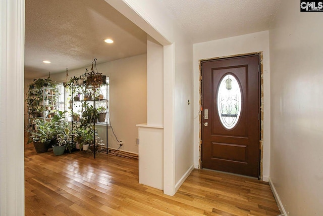 foyer featuring a textured ceiling and light wood-type flooring