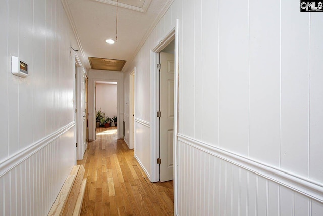 hall featuring light hardwood / wood-style floors and crown molding