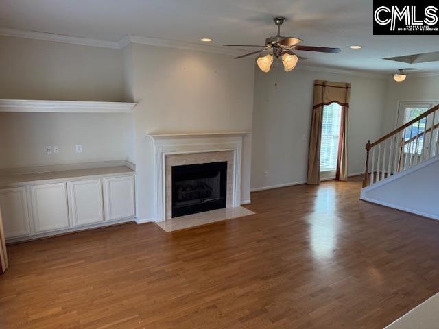 unfurnished living room with crown molding, wood-type flooring, and ceiling fan