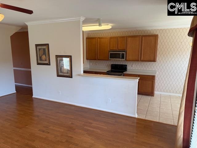 kitchen with light hardwood / wood-style floors, black stove, ceiling fan, and crown molding