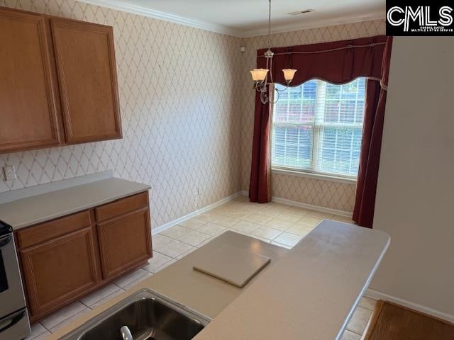 kitchen featuring sink, light tile patterned floors, crown molding, and an inviting chandelier