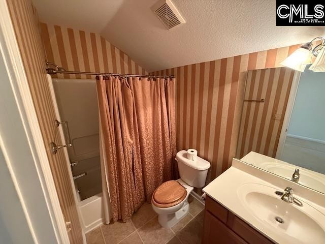 full bathroom featuring shower / bath combo, toilet, tile patterned floors, lofted ceiling, and vanity