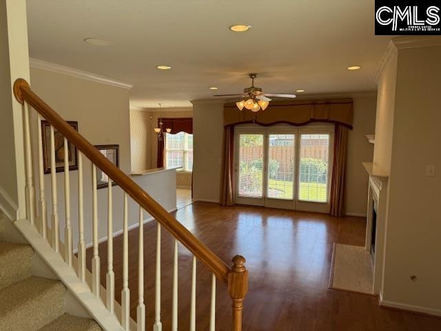 staircase featuring crown molding, wood-type flooring, and ceiling fan