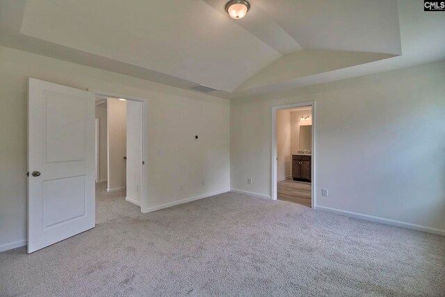 unfurnished room featuring light carpet and vaulted ceiling