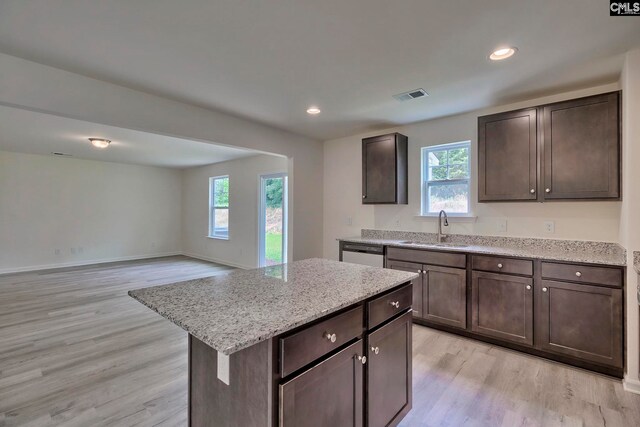 kitchen featuring a center island, a healthy amount of sunlight, sink, and light hardwood / wood-style flooring