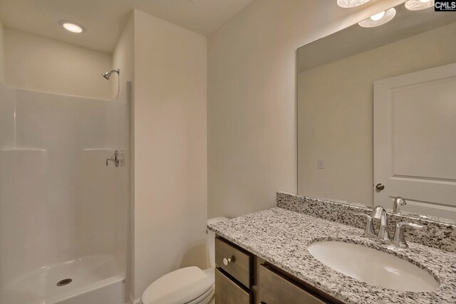 bathroom with toilet, a shower, and vanity