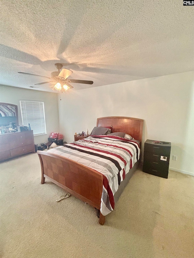 bedroom with carpet flooring, a ceiling fan, and a textured ceiling